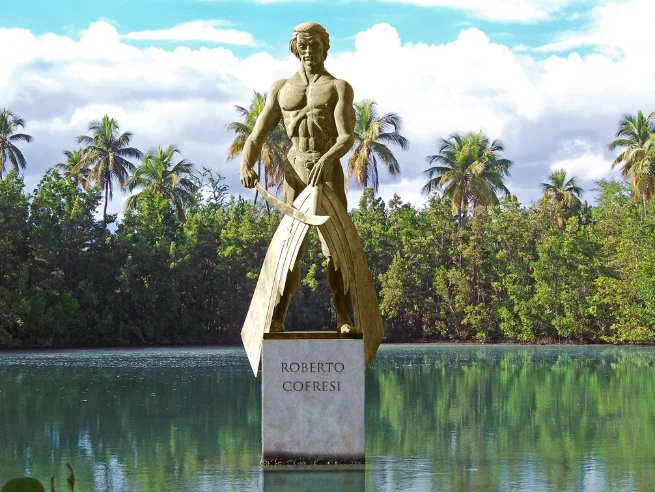 Photographie d'un monument portant le nom de Roberto Cofresí dans un paysage tropical.